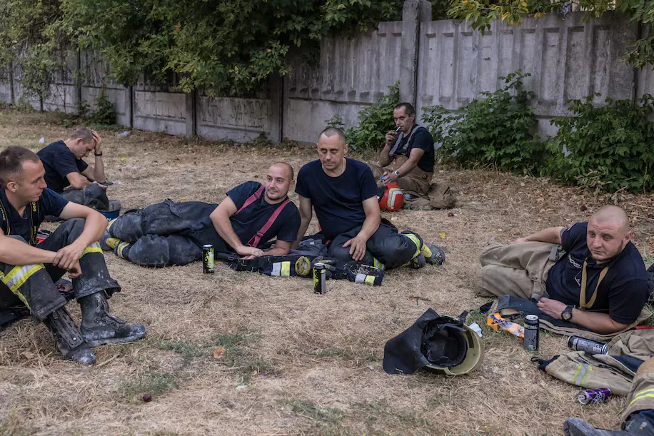 Співробітники МНС відпочивають далеко від місця російського удару під час повітряної тривоги у вівторок у Полтаві.